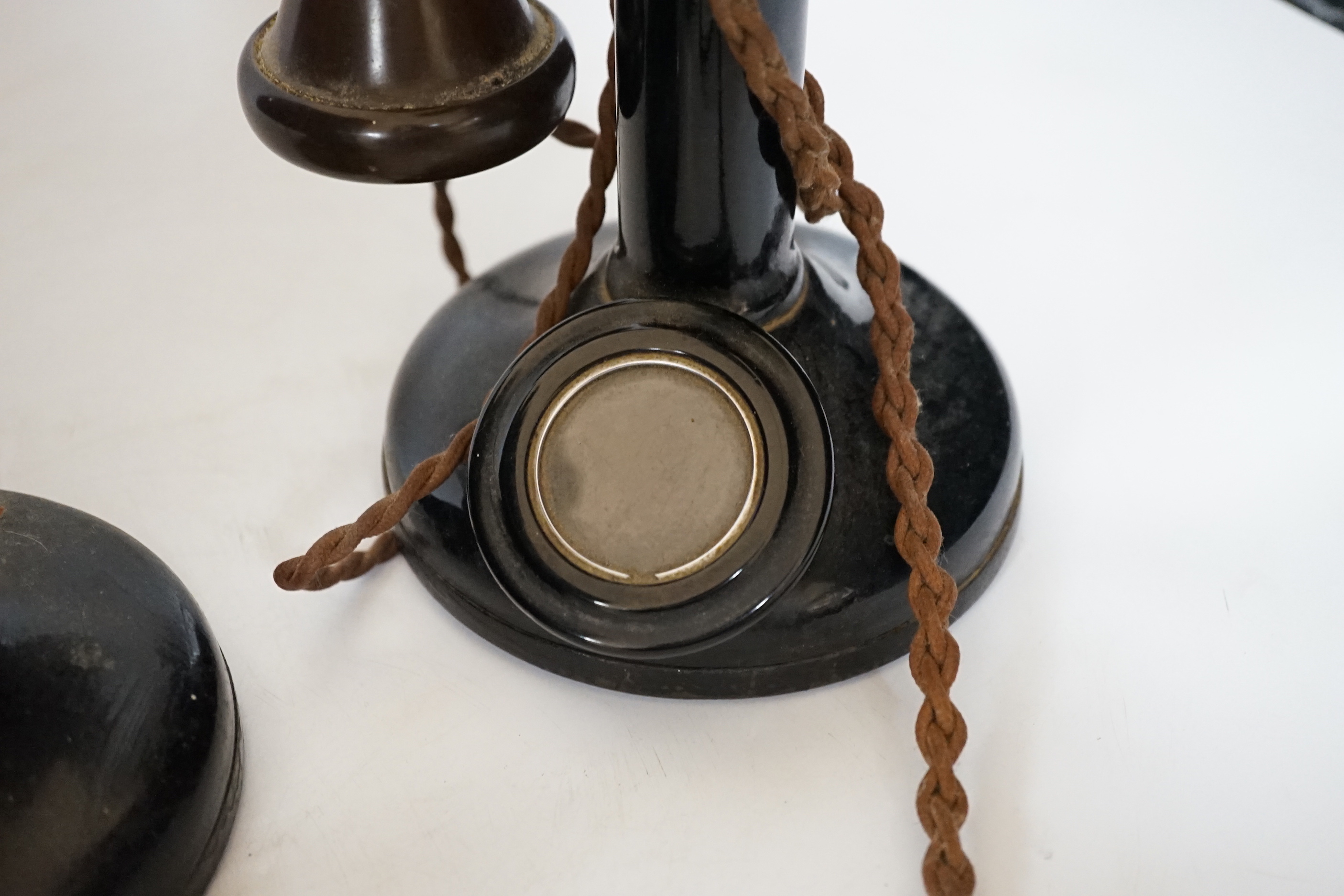 Two early black Bakelite pillar telephones, 31cm high